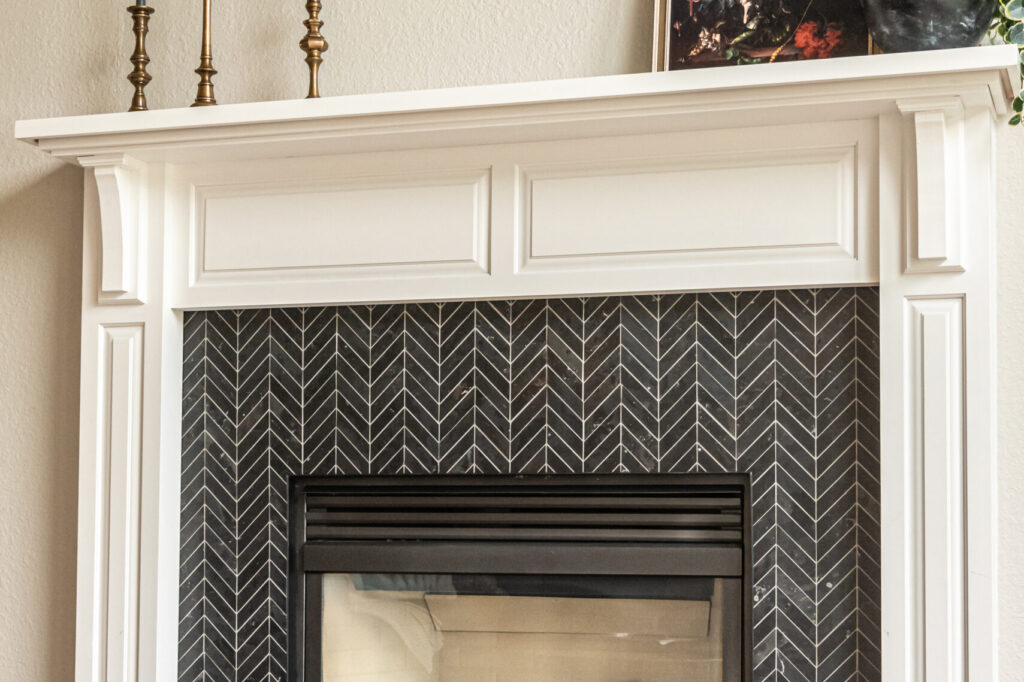 Black chevron tile fireplace against white trim and walls