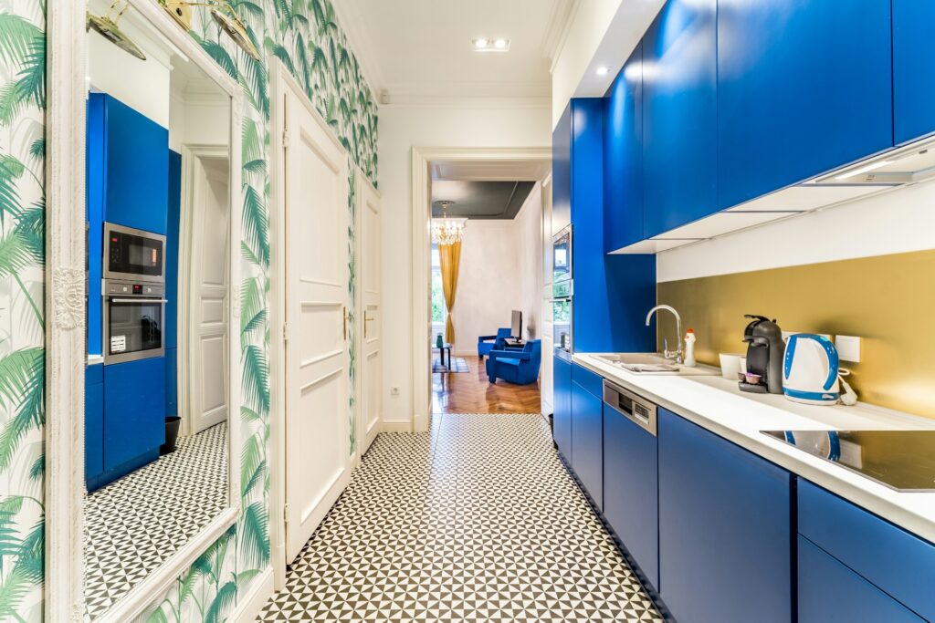 Kitchen with blue cupboards and gold backsplash