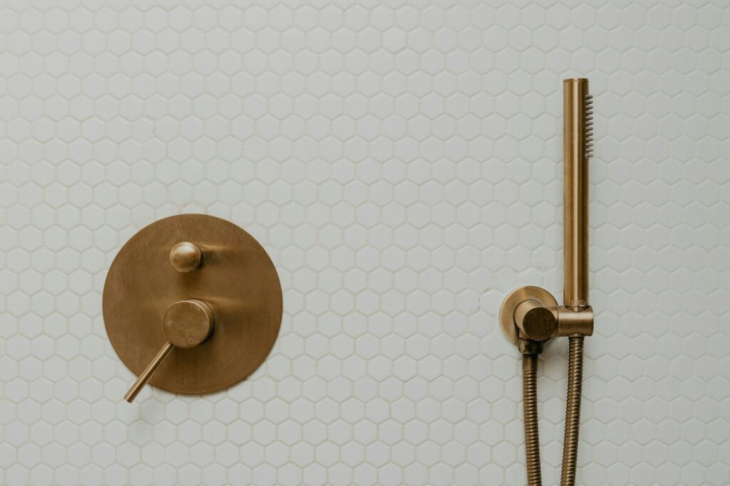 White hexagon tiles on tub surround with gold fixtures