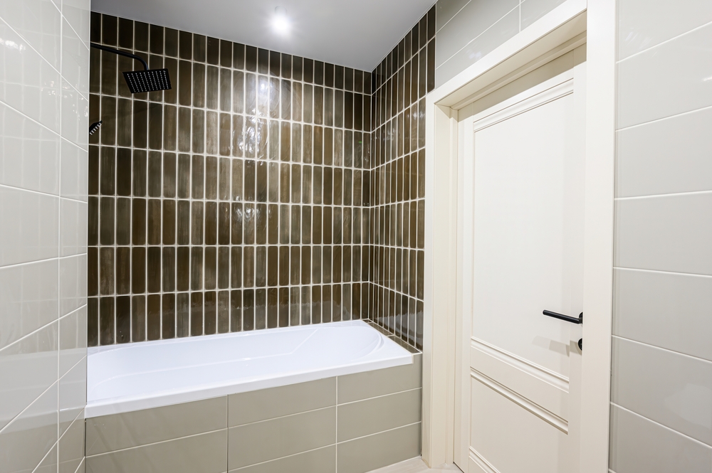 Brown vertical tiles in a small bathroom's shower